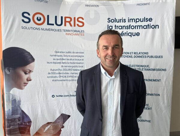 M. Francis Ludwig, Président de Soluris devant affiche